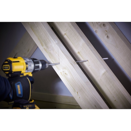 IRWIN 10502830 drill bit installed in a power drill boring through light wood beams, close-up action shot.