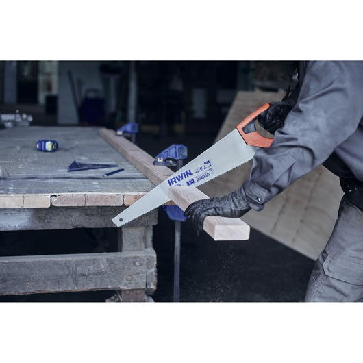 IRWIN hand saw 10505212 with orange handle cutting wood in workshop.