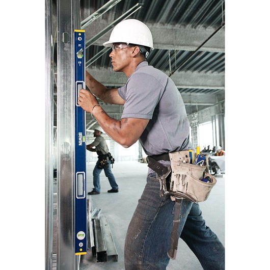 Photo of worker using IRWIN 1794067 blue spirit level on metal frame at construction site.