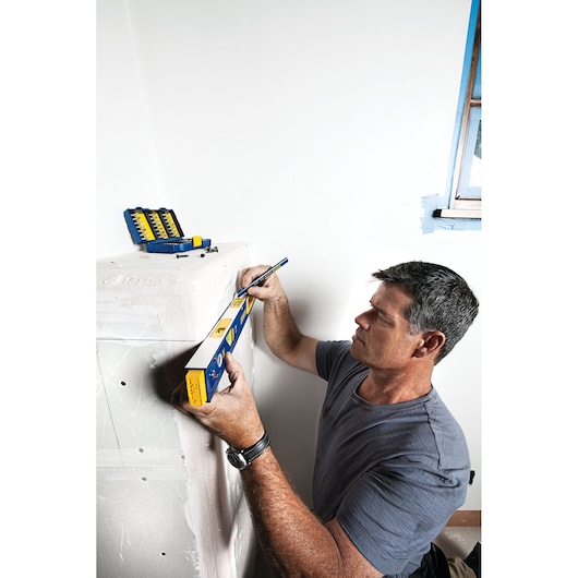 IRWIN 1794075 spirit level and drill bit set in use marking a wall during home renovation.