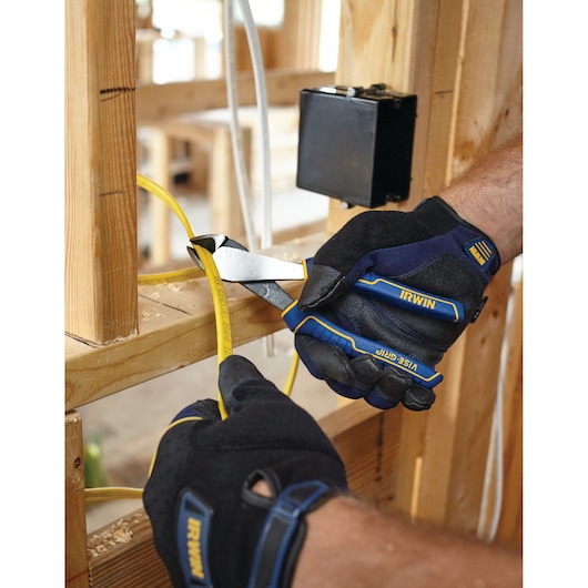 Photo of IRWIN 1968333 cutting pliers with blue and yellow handles cutting yellow electrical wire, worker wearing gloves.