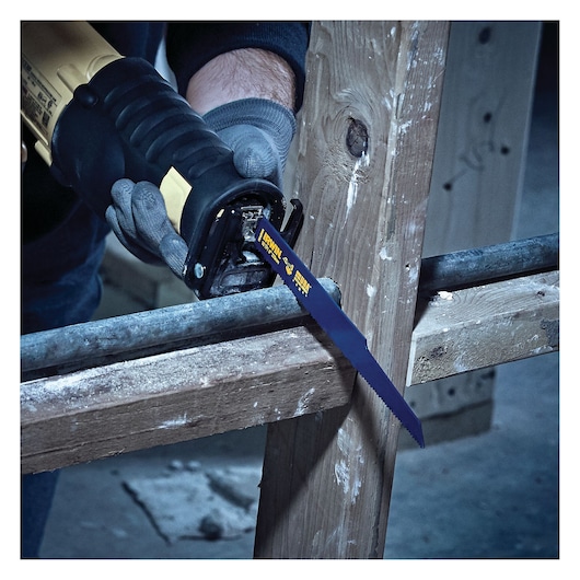 IRWIN 2018874 reciprocating saw blade cutting metal pipe, close-up action scene with gloved hands.