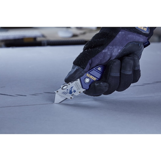 IRWIN utility knife SKU 2089100 in gloved hand cutting drywall, close-up photography.