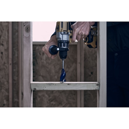 IRWIN drill bit 3041009 close-up in use with a power drill on a wooden frame, construction setting.