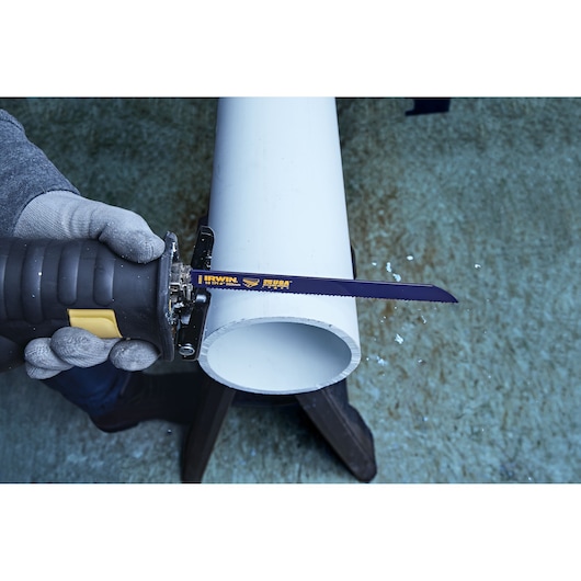 IRWIN 372810 reciprocating saw blade cutting white PVC pipe, close-up photo.