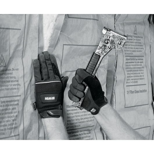 IRWIN 432005 work gloves shown on hands installing insulation with a staple hammer, close-up front view.
