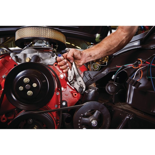 IRWIN IRHT82573 locking pliers clamping a bolt on a red car engine during automotive repair.