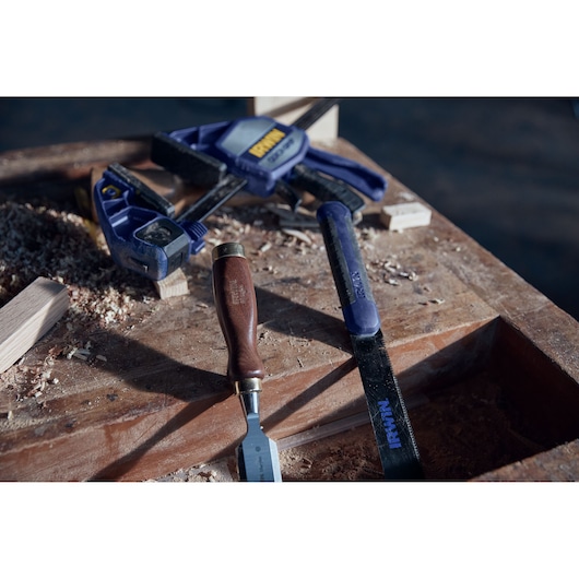 IRWIN 2011491 woodworking tools and clamp on workbench with wood shavings, close-up, photography.