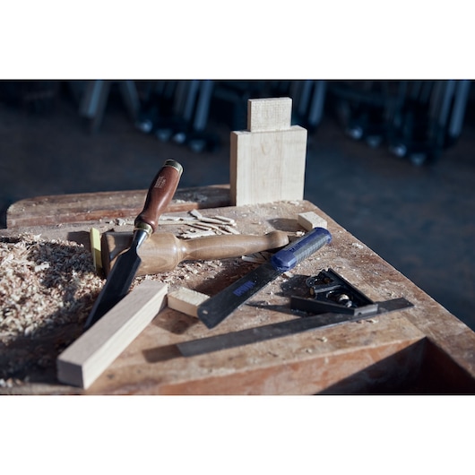IRWIN 2011491 woodworking tools and wood pieces on a workbench with shavings in workshop setting.
