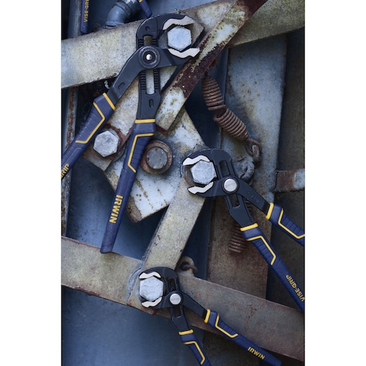 Photo of three IRWIN 2078112 groove joint pliers with blue and yellow handles gripping metal bolts on industrial metal parts.