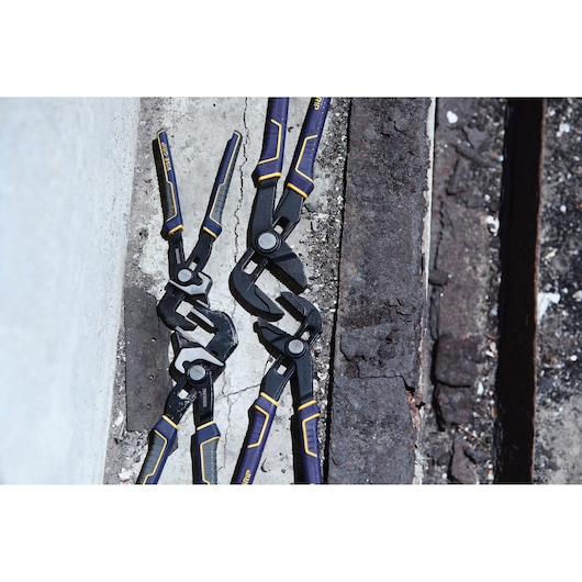 Photo of IRWIN IRHT82636 adjustable pliers, black with yellow and blue handles, placed on concrete and metal.