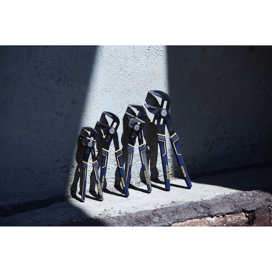 Photo of four IRWIN adjustable groove joint pliers IRHT82636 with blue and yellow handles lined up against a concrete wall.