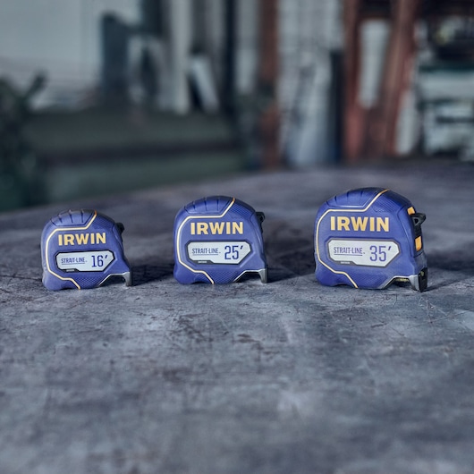 Photo of three IRWIN tape measures, models 16', 25', and 35', blue and yellow, on a workbench, SKU IWHT39391S.
