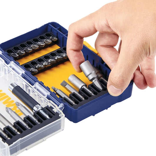 Photo of IRWIN IWAF1224 drill and screwdriver bit set in a blue and clear case with a hand selecting a bit, front angle.