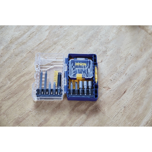 IRWIN IWAF1224 screwdriving bit set with open clear plastic case on wood surface, assorted bits and holders visible.