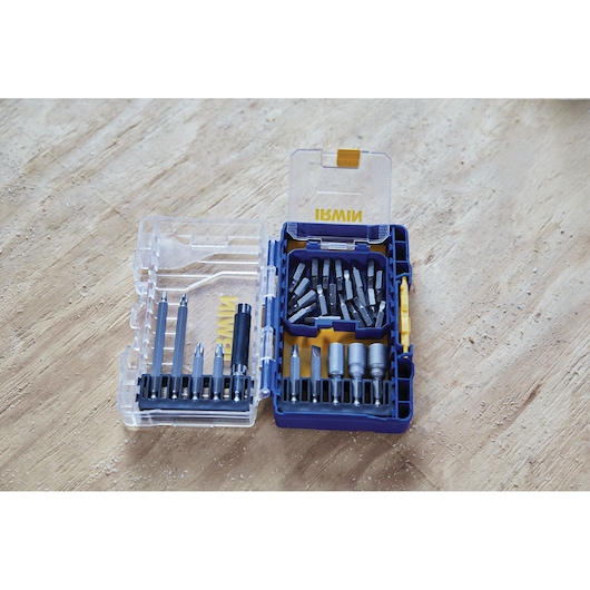 IRWIN IWAF1224 drill and driver bit set in blue and clear plastic case, opened to show assorted bits on wood surface.
