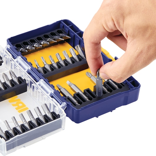 IRWIN IWAF1240 screwdriver bit set in blue and yellow case, hand removing a bit, close-up angle.