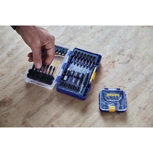 Photo of IRWIN IWAF1326 drill and bit set in blue plastic case with various bits, hand selecting a bit.