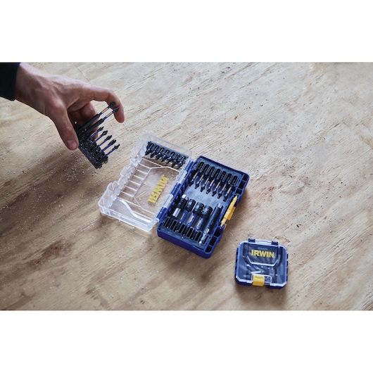 IRWIN IWAF1326 photography of drill bit set in blue and clear case on wooden surface, hand holding bits.