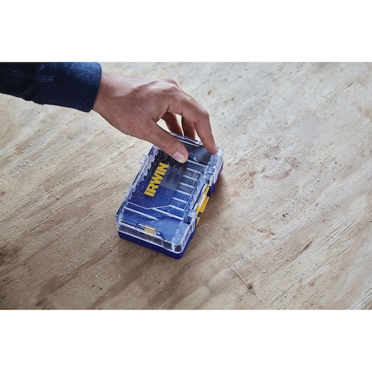 Photo of IRWIN IWAF1326 small blue and clear plastic tool box being held on a wooden surface.