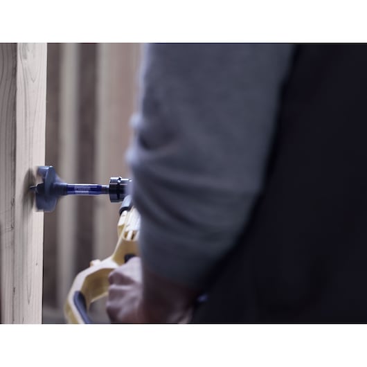 IRWIN spade bit IWAX2008 attached to a power drill, drilling into a vertical wood beam.