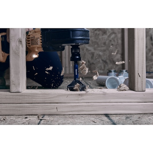 IRWIN IWAX2008 wood drill bit in action, mounted on a power tool, cutting through timber with wood shavings flying.