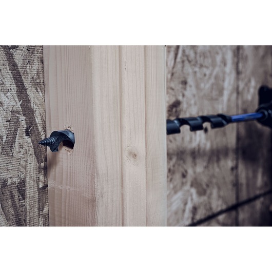 IRWIN IWAX3009 auger drill bit drilling through wood beam, close-up angle.