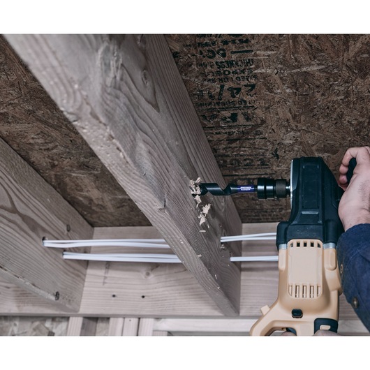 IRWIN IWAX3017 auger bit drilling through wooden beam with power drill in construction setting.
