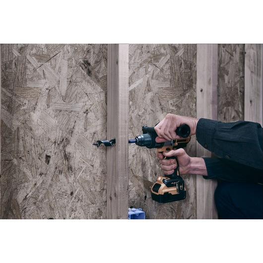 IRWIN drill bit IWAX3017 drilling through wood with a cordless drill, side view.