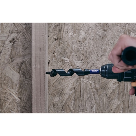 IRWIN IWAX3017 auger drill bit attached to power drill, drilling into wood with close-up side view.