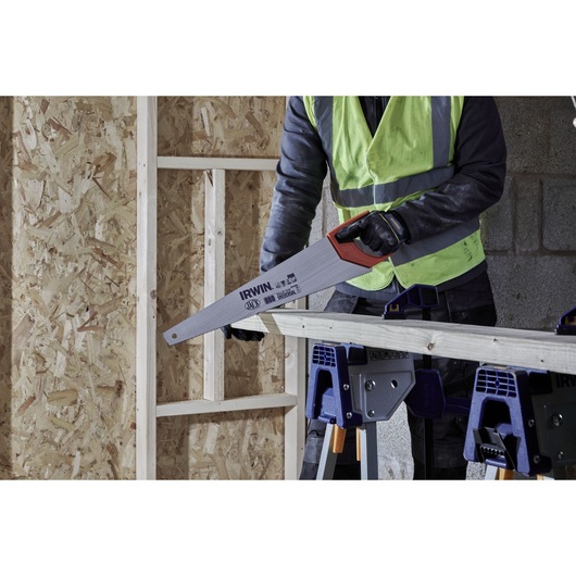 IRWIN hand saw IWHT20385-3 used by worker in high visibility vest cutting wood on jobsite.