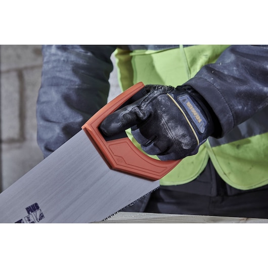 Photo of IRWIN hand saw IWHT20385-3 with orange handle, held by gloved hand, cutting wood.