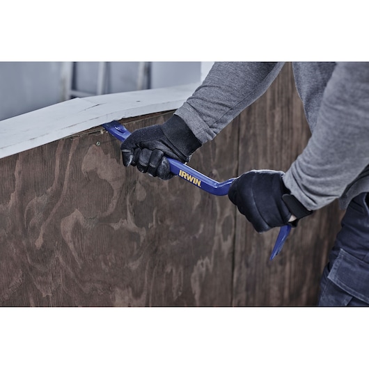 Photo of IRWIN IWHT55180 steel pry bar being used to remove paneling, worker wearing gloves.